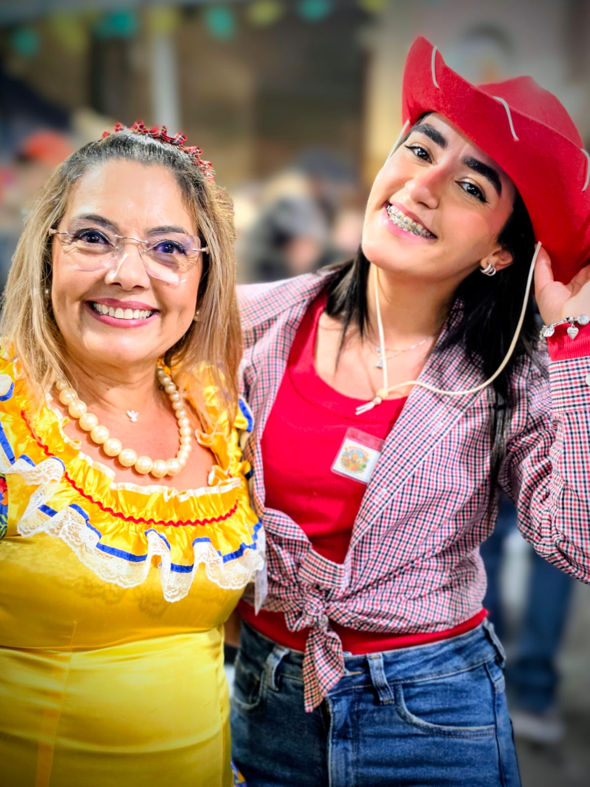 Mãe e filha em trajes juninos sorrindo na quermesse